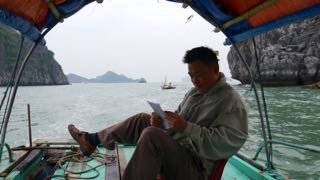 our guide's a real pro, casually steering with his foot while checking the map. cat ba.